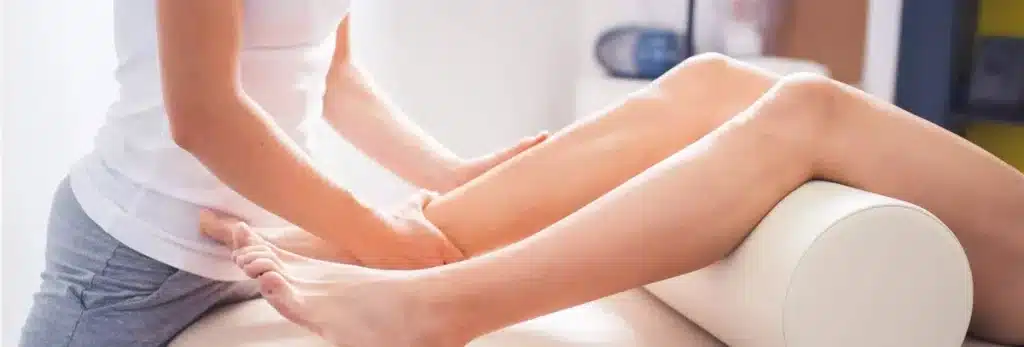 fisioterapeuta tratando dolencia piernas mujer